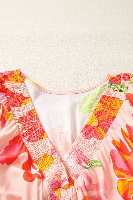 A flowy maxi dress with a vibrant floral print in pink, orange, and green.