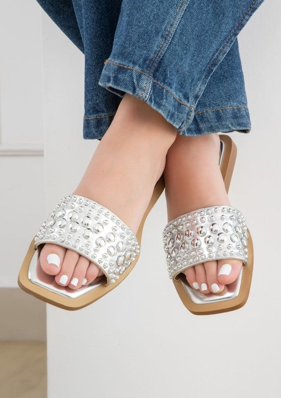 Slip-on sandals with pearl and stud embellished upper band, square toe silhouette, flat sole, and open-toe design