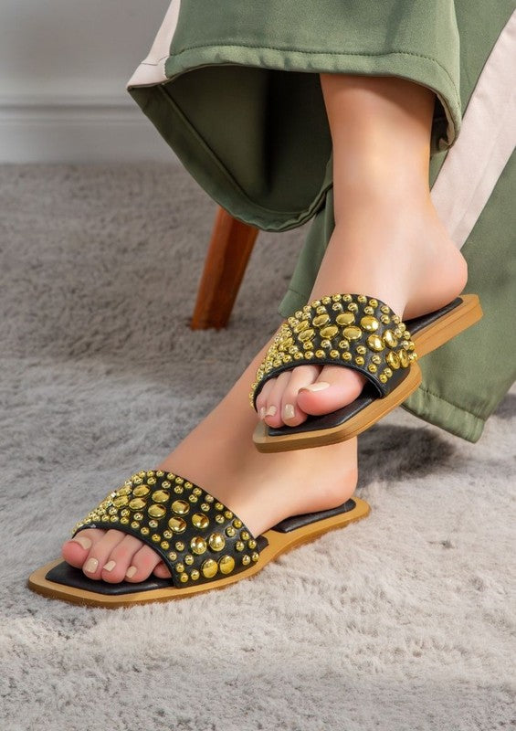 Slip-on sandals with pearl and stud embellished upper band, square toe silhouette, flat sole, and open-toe design