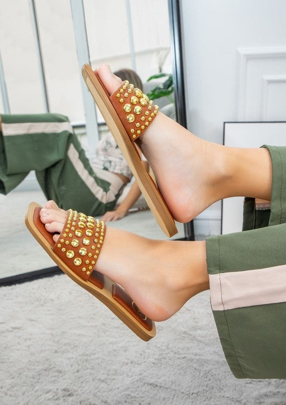 Slip-on sandals with pearl and stud embellished upper band, square toe silhouette, flat sole, and open-toe design