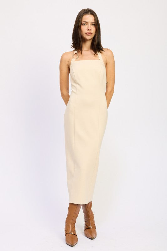 Woman models a chic halter neck midi dress in a neutral cream color, featuring a fitted silhouette and elegant design, full front view.