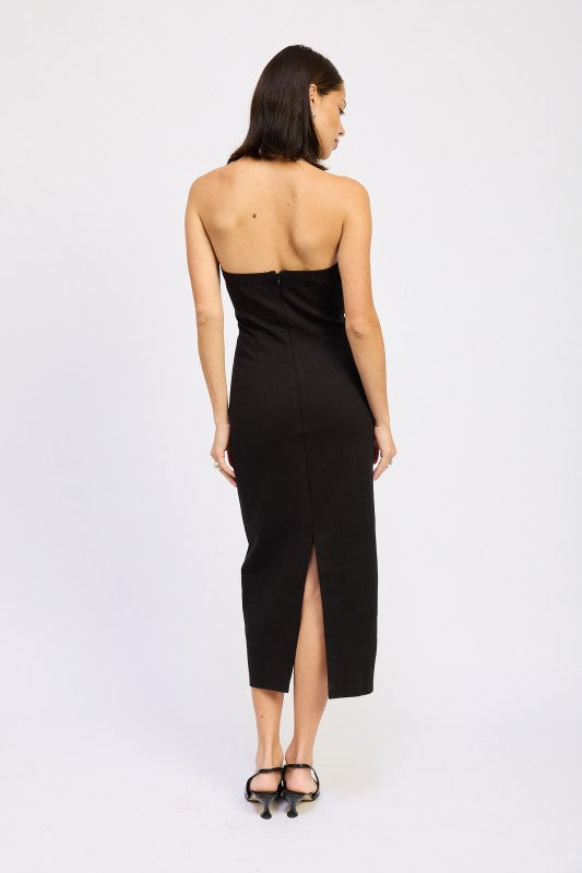 Woman models a chic halter neck midi dress in a black color, featuring an elegant design, back view.