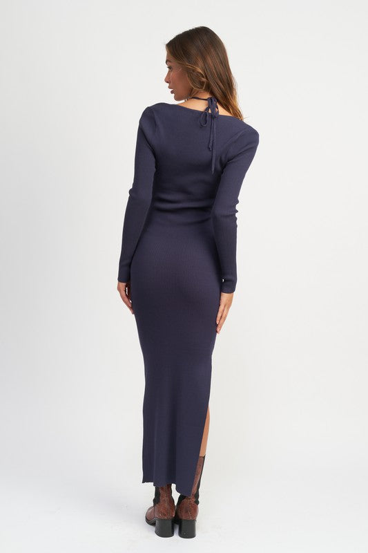 Woman wearing a long-sleeve navy dress with a slit on a white background