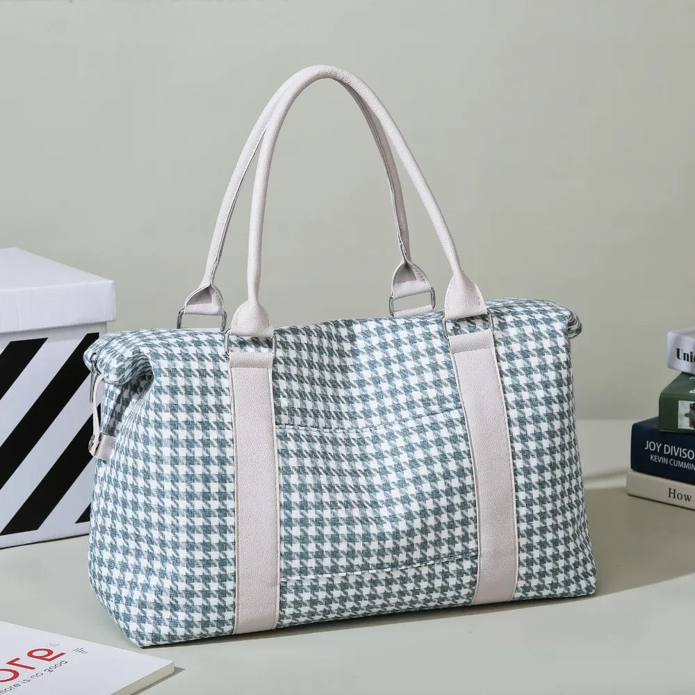 Green and white houndstooth handbag with light beige handles and rounded edges, placed near books and a striped box. Soft, structured, and stylish—ideal for everyday or semi-formal use.