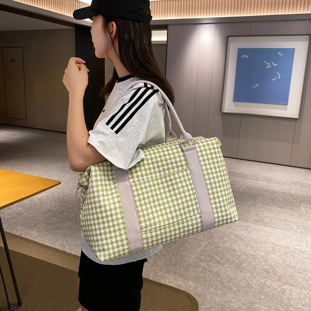 A lady hanging a green and white houndstooth handbag with light beige handles and trim, placed beside stacked books. Soft, structured, and stylish—ideal for casual or semi-formal use.