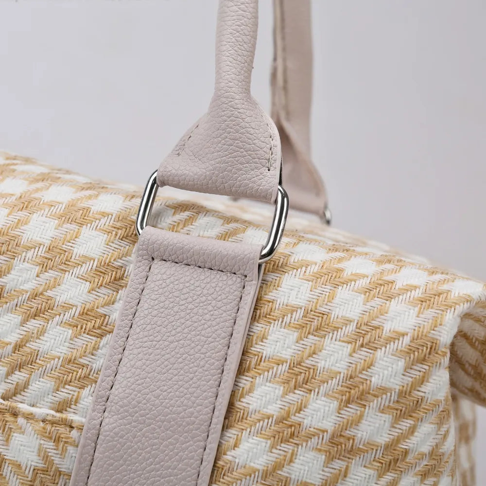 Beige and white houndstooth handbag with light gray handles and a structured, rounded shape. Soft and stylish—perfect for everyday fashion.