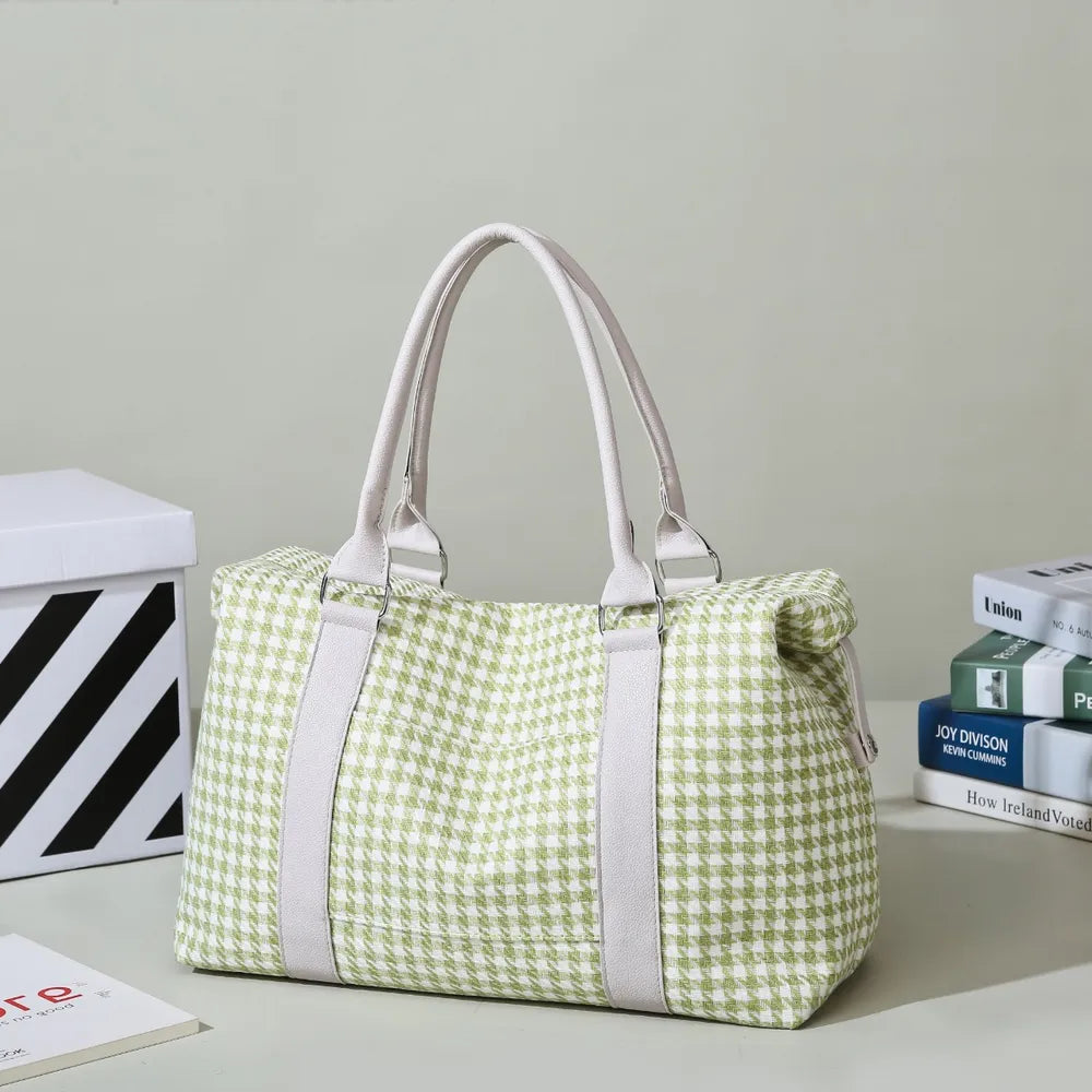 Green and white houndstooth handbag with light beige handles and trim, placed beside stacked books. Soft, structured, and stylish—ideal for casual or semi-formal use.