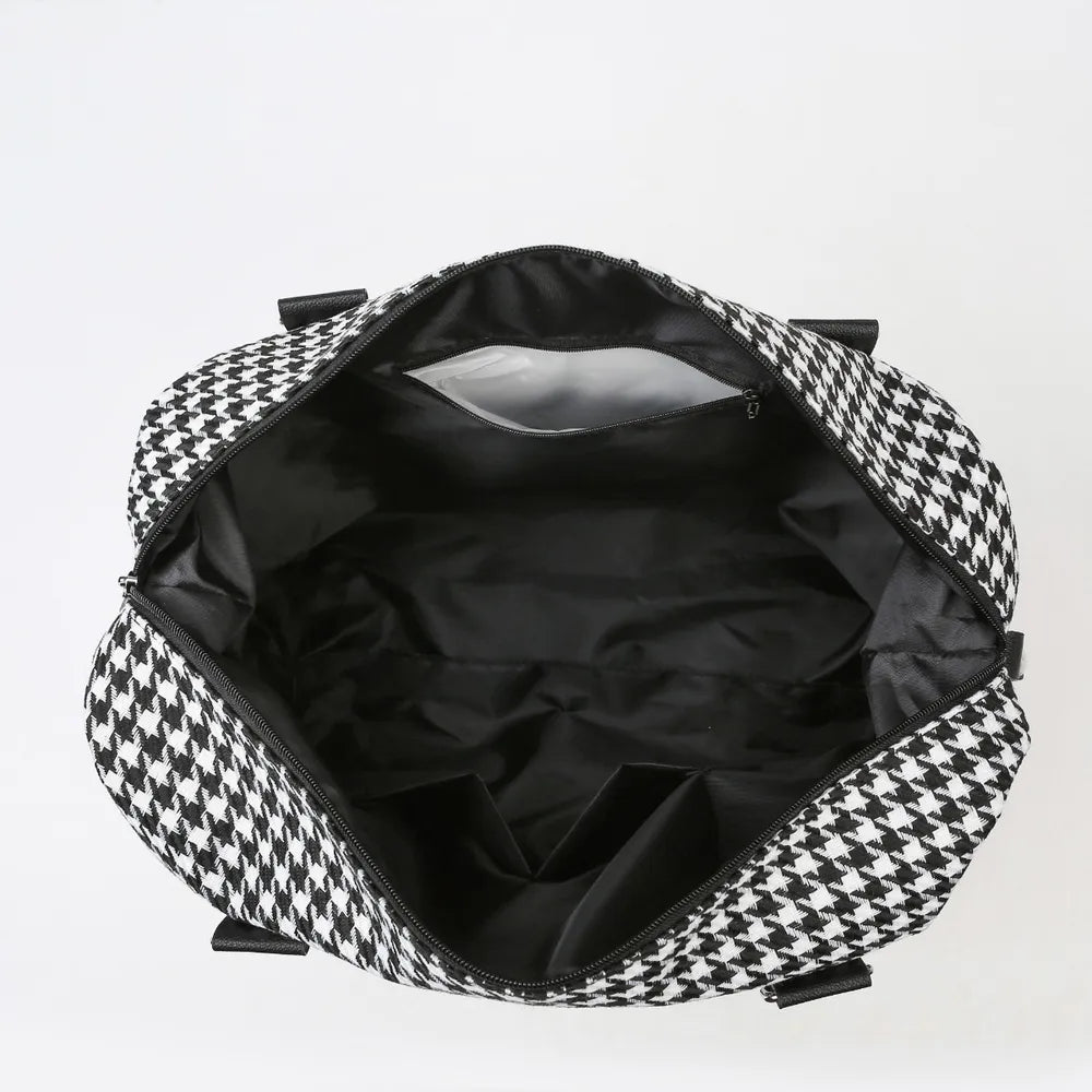 Open black and white houndstooth bag with a spacious black-lined interior and multiple organizing pockets. Stylish and practical—ideal for everyday use.