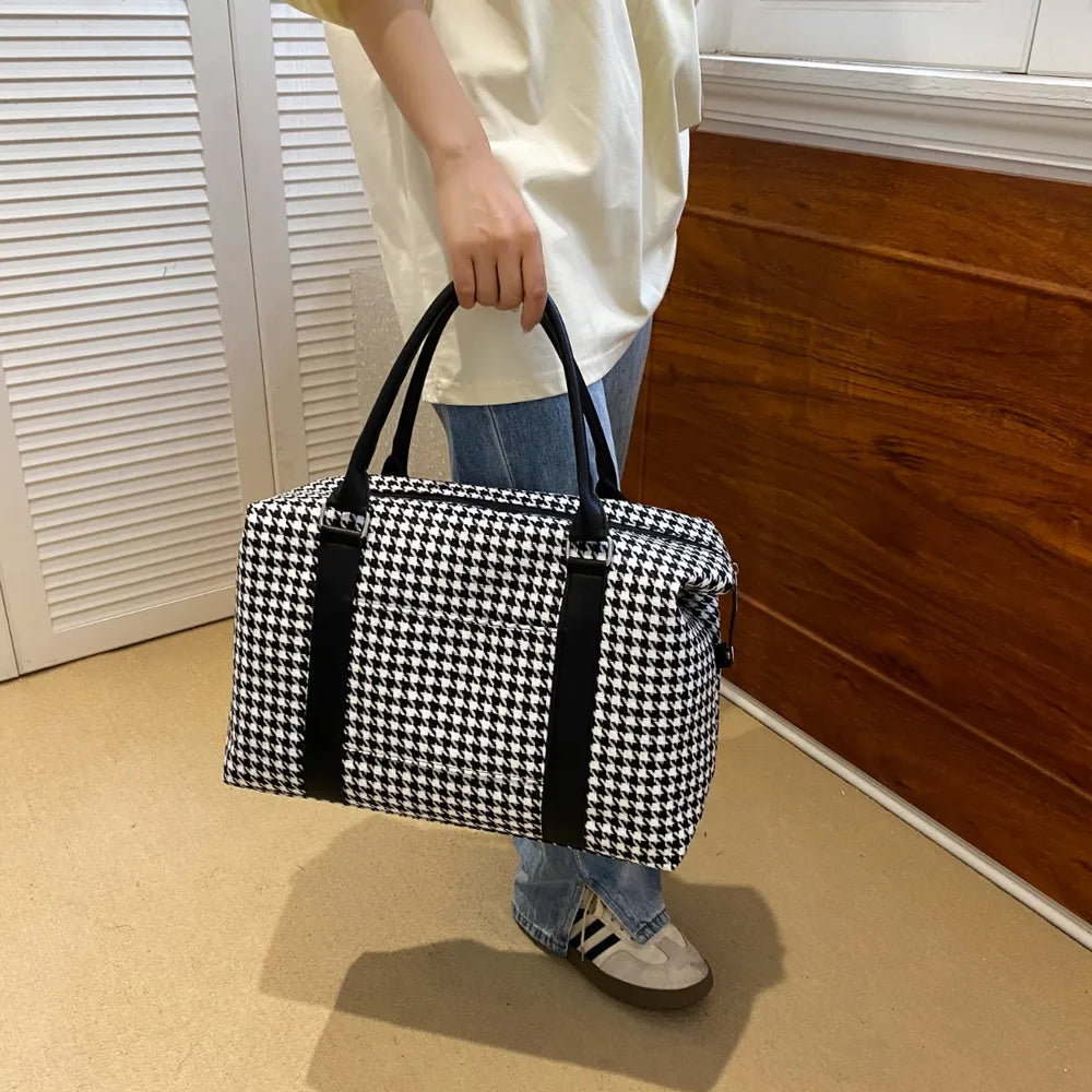 Black and white houndstooth handbag with black leather handles and accents, featuring a structured rectangular shape. Chic and modern—perfect for stylish everyday wear.