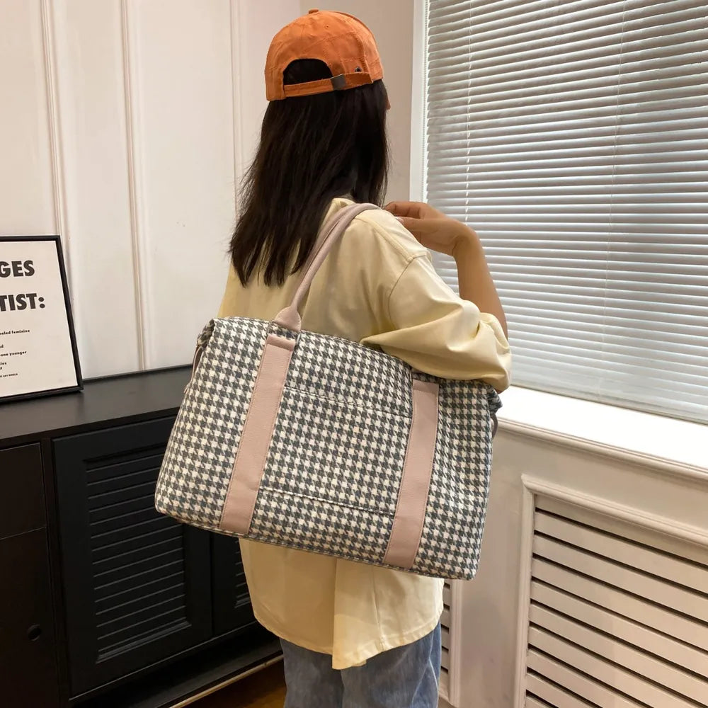 A lady hanging a green and white houndstooth handbag with light beige handles and rounded edges, placed near books and a striped box. Soft, structured, and stylish—ideal for everyday or semi-formal use.