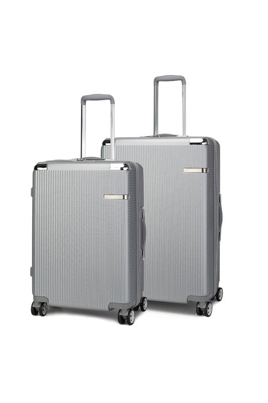 Two silver hard-shell suitcases with vertical ridges, extended telescopic handles, and spinner wheels—standing upright side by side, with one slightly larger than the other.