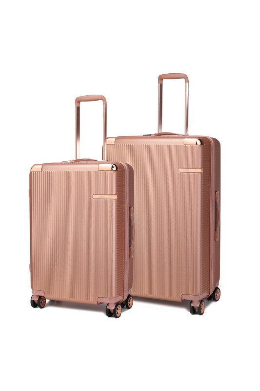 Two rose gold hard-shell suitcases with vertical ridges, extended telescopic handles, and spinner wheels—standing side by side, with the left one smaller than the right.