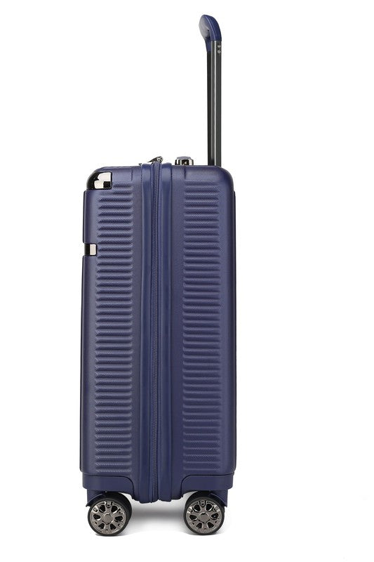 Dark blue hard-shell suitcase with vertical ribbed texture, extended telescopic handle, and four spinner wheels—standing upright on a wooden floor.