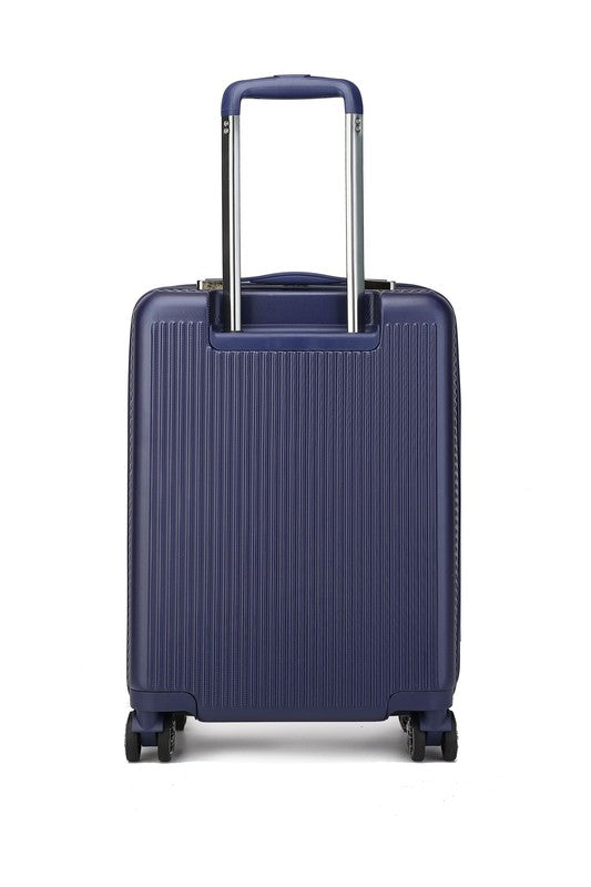 Dark blue hard-shell suitcase with vertical ribbed texture, extended telescopic handle, and four spinner wheels—standing upright on a wooden floor.