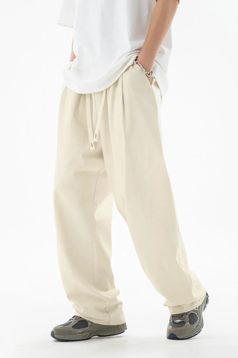Person wearing beige pants and a white shirt on a white background