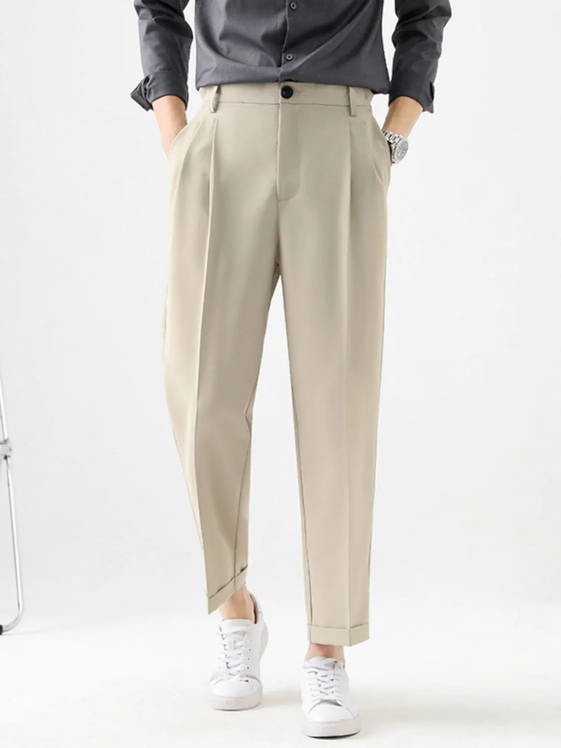 Person wearing beige pants and a dark shirt on a white background