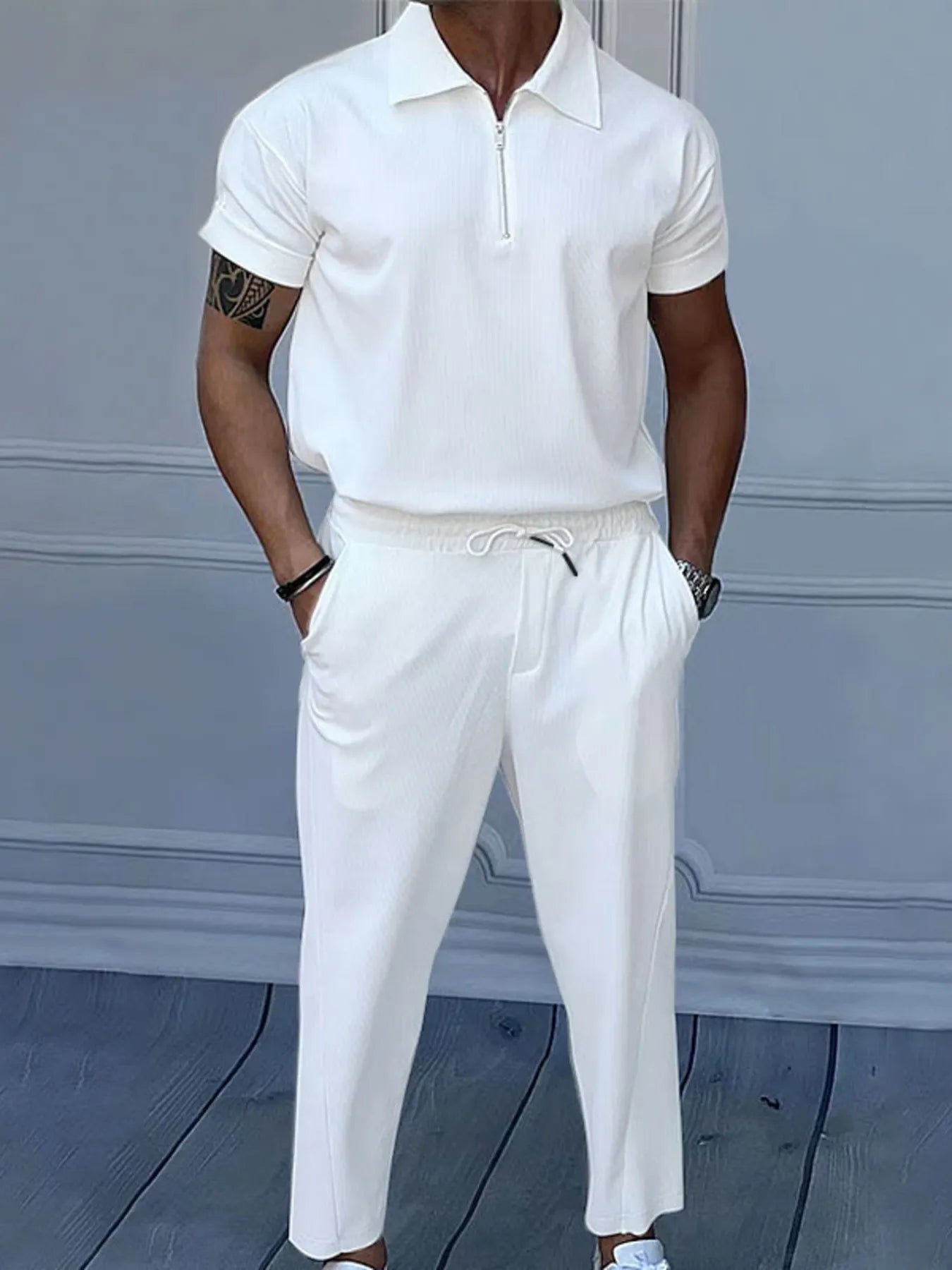 This is a plus-size men's two-piece set featuring a quarter-zip polo with short sleeves and matching pants, designed for comfortable, easy-wear versatility.