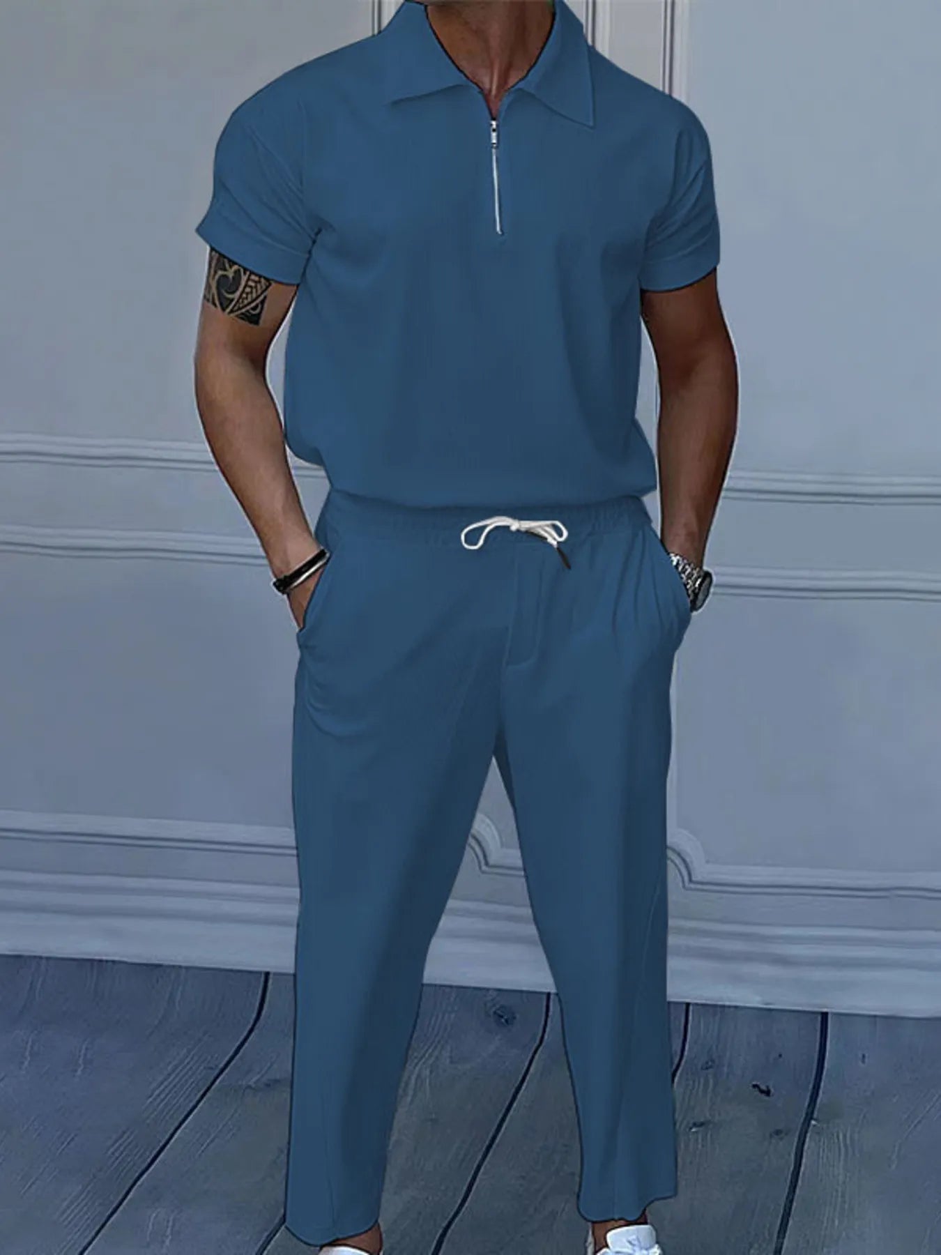 This is a plus-size men's two-piece set featuring a quarter-zip polo with short sleeves and matching pants, designed for comfortable, easy-wear versatility.