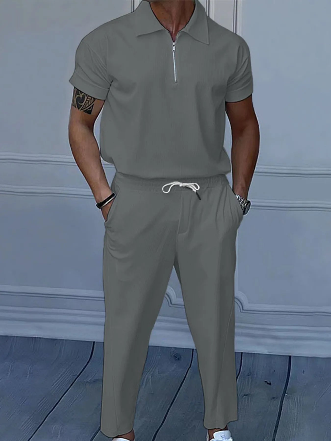 This is a plus-size men's two-piece set featuring a quarter-zip polo with short sleeves and matching pants, designed for comfortable, easy-wear versatility.