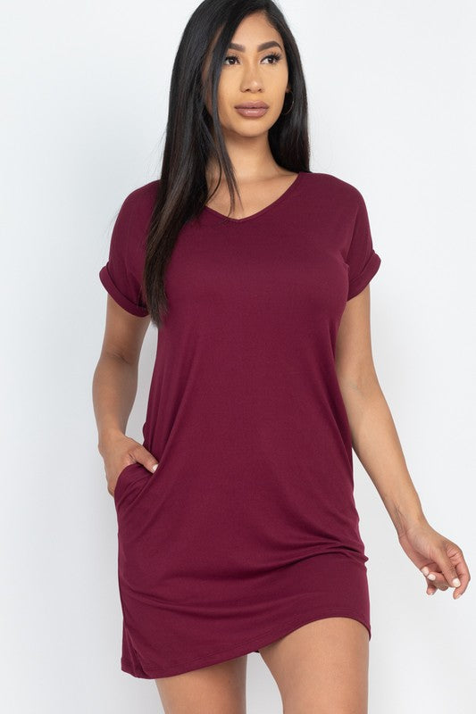 Woman wearing a burgundy t-shirt dress against a white background