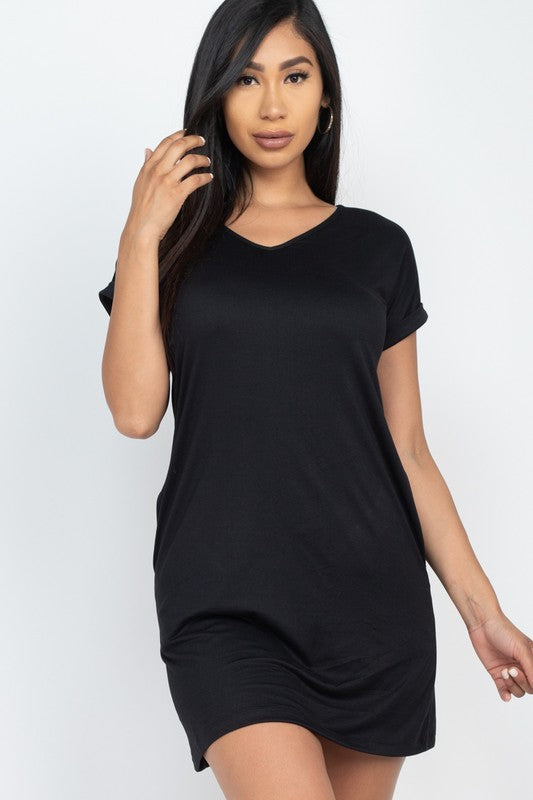 Woman wearing a black t-shirt dress against a white background