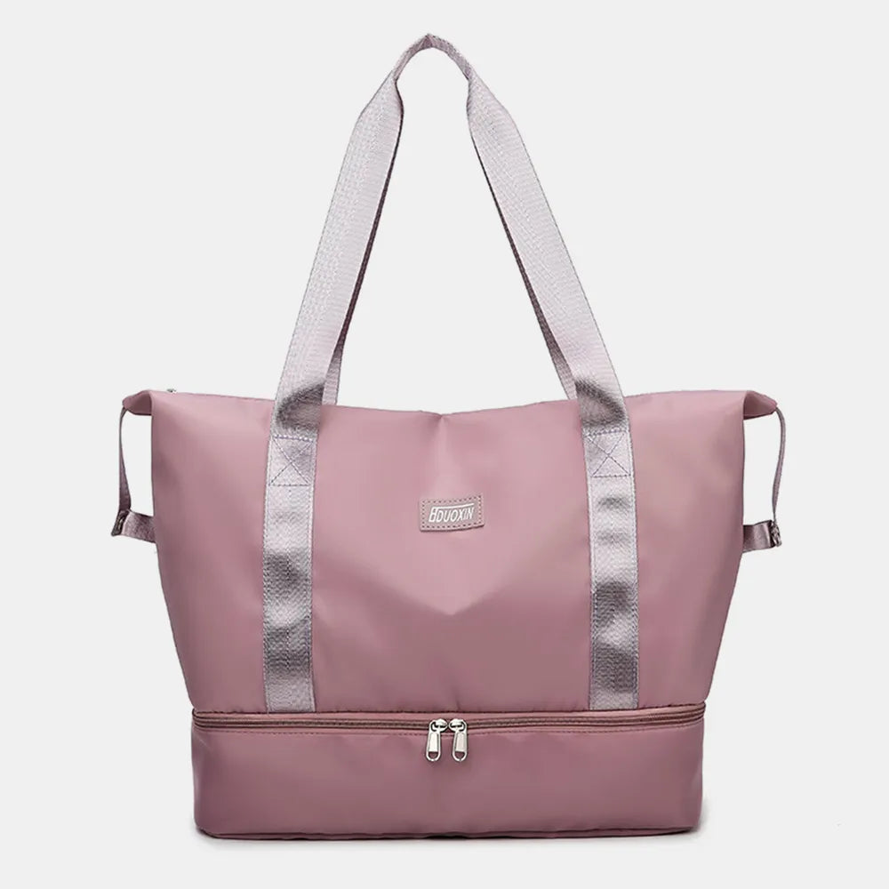 Pink travel bag with light gray straps and a zippered bottom compartment, set against a white backdrop with geometric decor. Sleek and functional—great for gym, travel, or daily use.