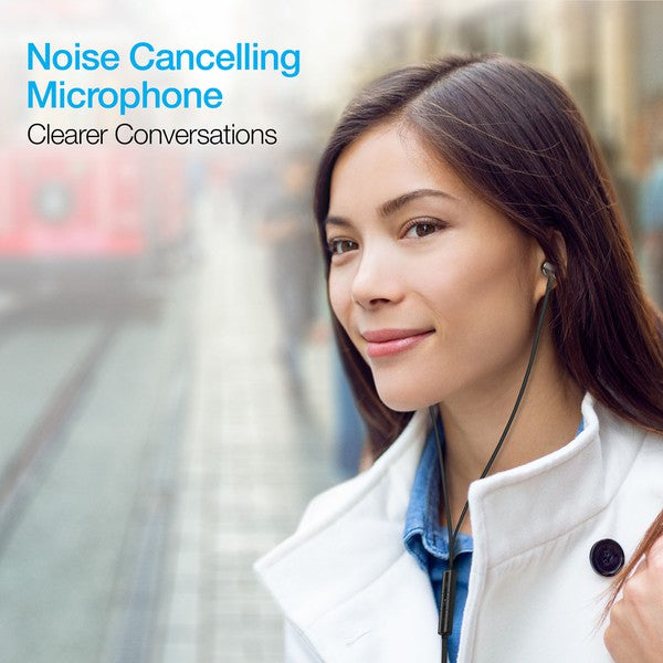 Woman wearing earphones with built-in mic on a city street—promotes noise-cancelling microphone for clearer conversations in noisy environments.