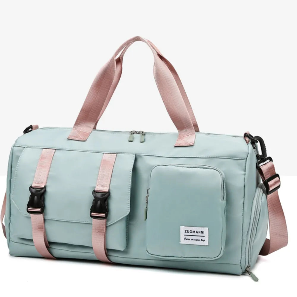 Green duffel bag with short handles and an adjustable shoulder strap, featuring a flap pocket with black buckles and a zippered front pocket.  Durable and stylish—ideal for gym or travel.