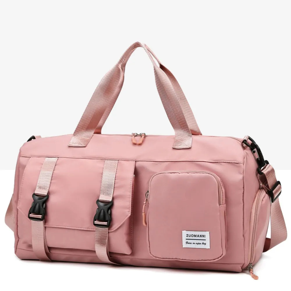 Pink duffel bag with short handles, adjustable shoulder strap, front buckle-strap pocket, and zippered compartment. Durable and stylish—ideal for gym or travel.