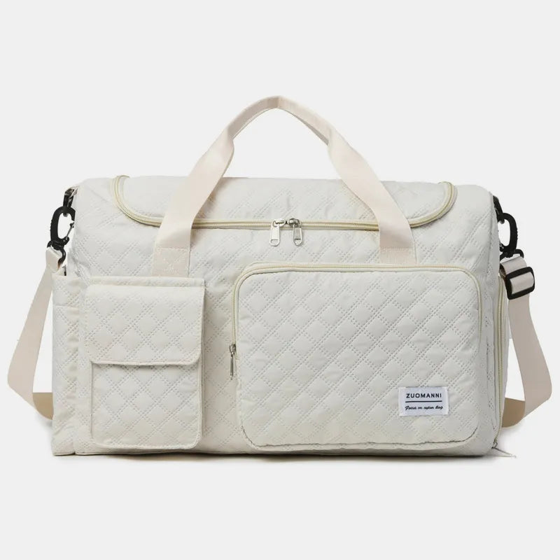 White quilted duffel bag with white straps, featuring a zip pocket and flap pocket on the front. Stylish and functional for travel or gym use.
