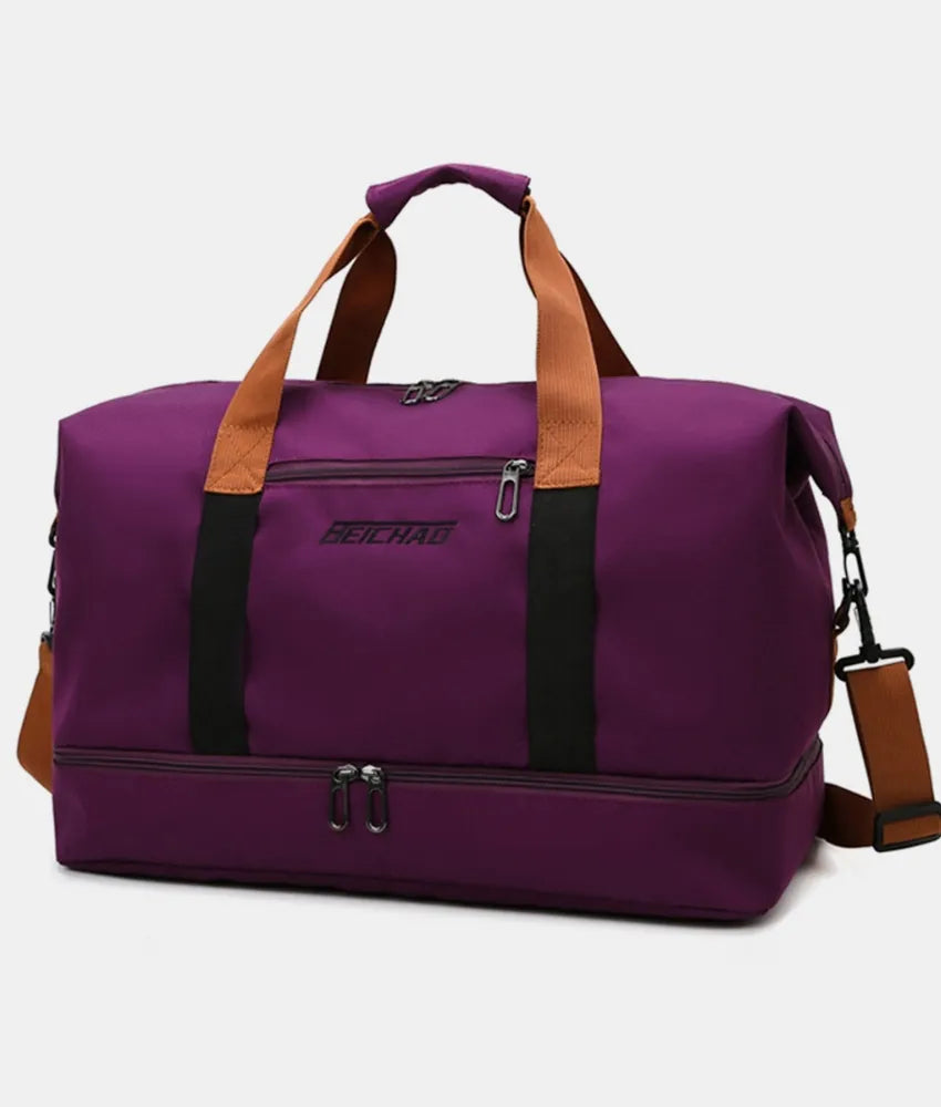 Purple duffel bag with brown handles and a black shoulder strap, featuring dual zippered compartments and a front label. Durable and stylish—ideal for gym, travel, or everyday use.