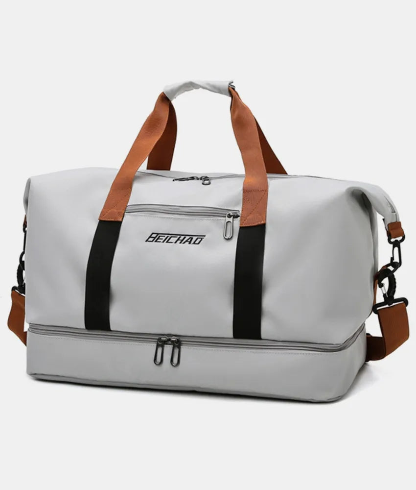Light gray duffel bag with brown and black straps, featuring a zippered top compartment and an additional bottom section. Sleek and functional—ideal for gym, travel, or everyday use.