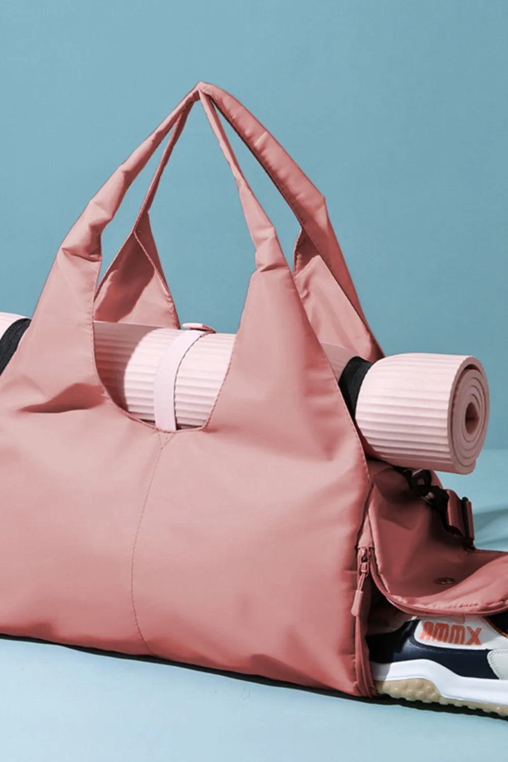 Pink gym bag with a rolled-up yoga mat secured on top and white-pink sneakers tucked into the side compartment. Stylish and functional—perfect for fitness on the go.