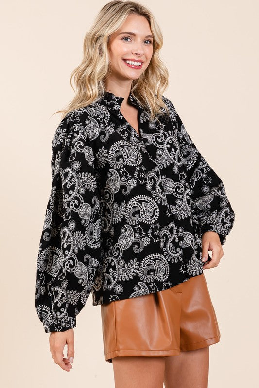 Ruffle trim at the neckline gives this blouse a delicate, vintage-inspired touch.