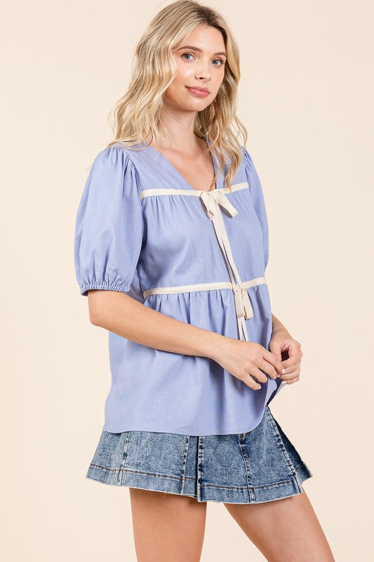 Feminine and fresh — this top’s piping detail adds polish to casual wear.