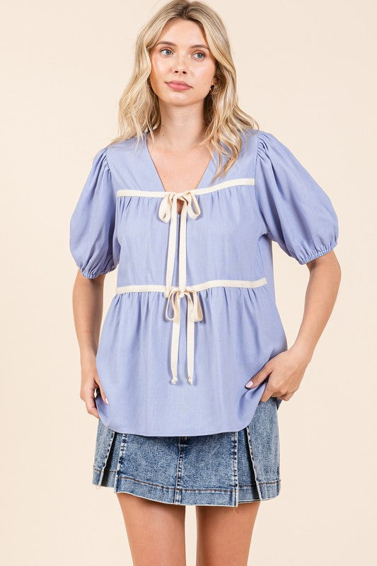 Piping detail gives this babydoll top a refined, tailored edge.