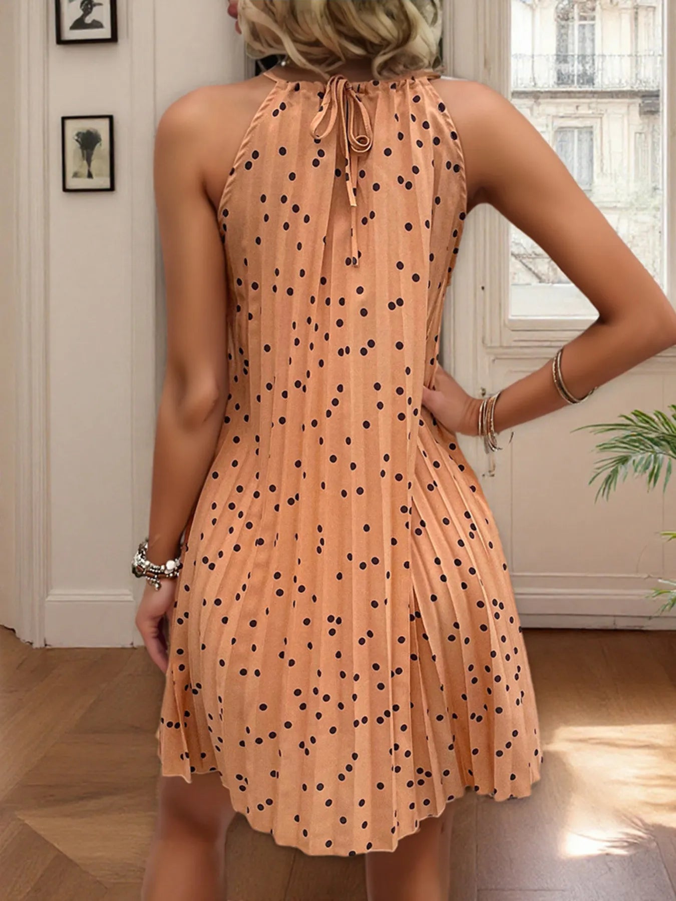 Sleeveless halter neck mini dress with black & white polka dot print and pleated skirt — flirty, structured style ideal for day or evening wear