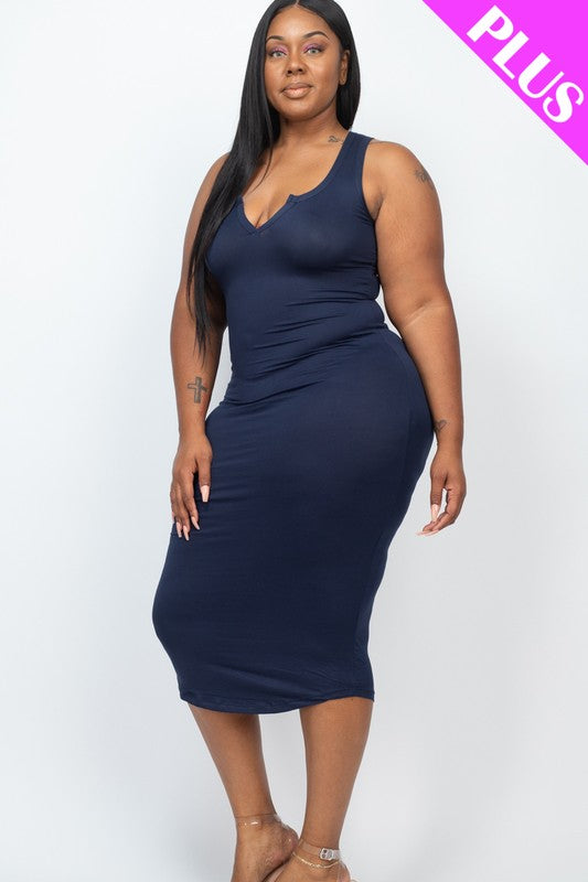A woman with long dark hair is standing on a beach wearing a navy blue bodycon dress and strappy heels. Waves are crashing in the background under a cloudy sky.