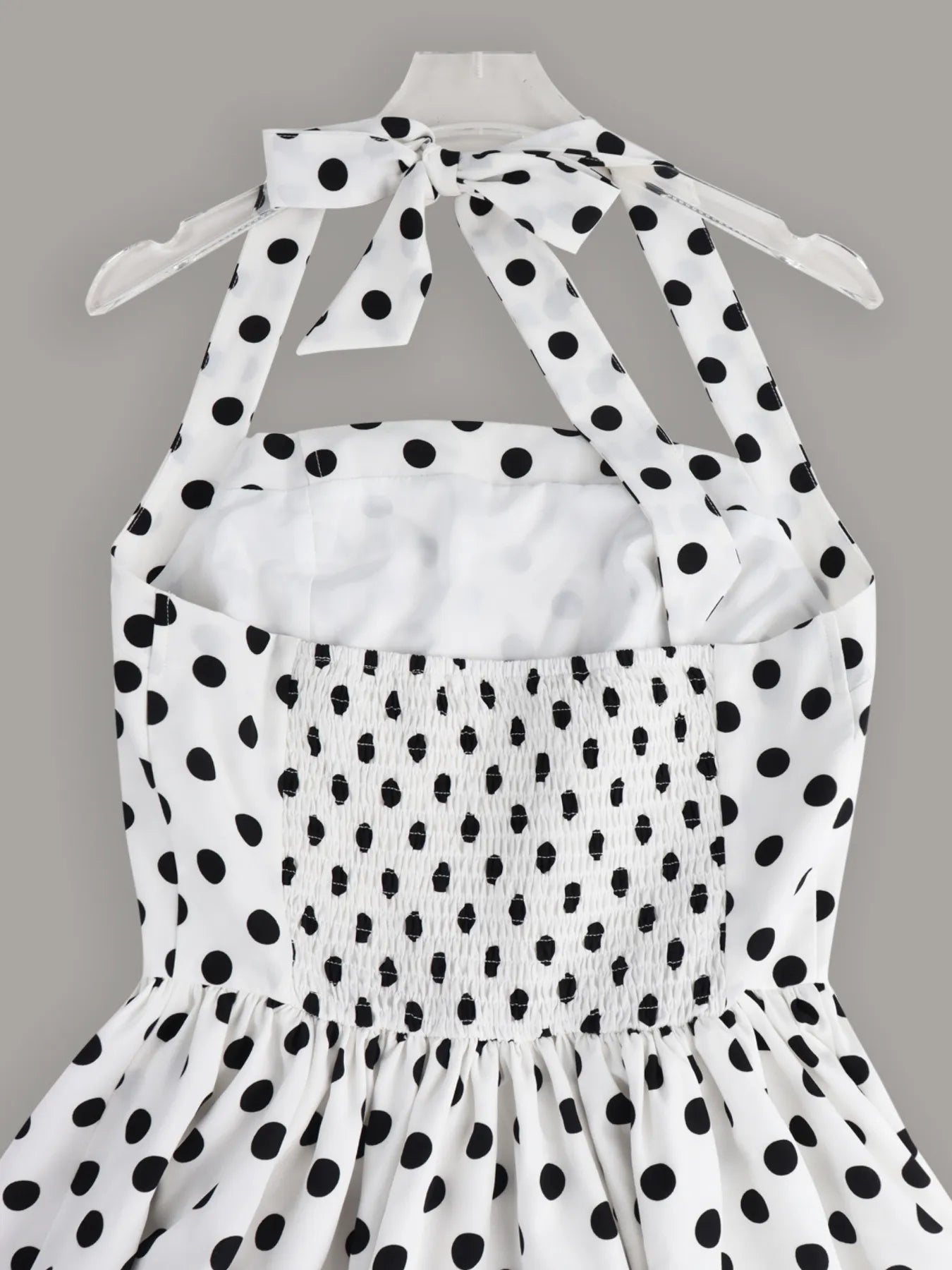 Sleeveless mini dress with halter neckline and polka dot print, fitted bodice and playful skirt — ideal for evening wear or warm days
