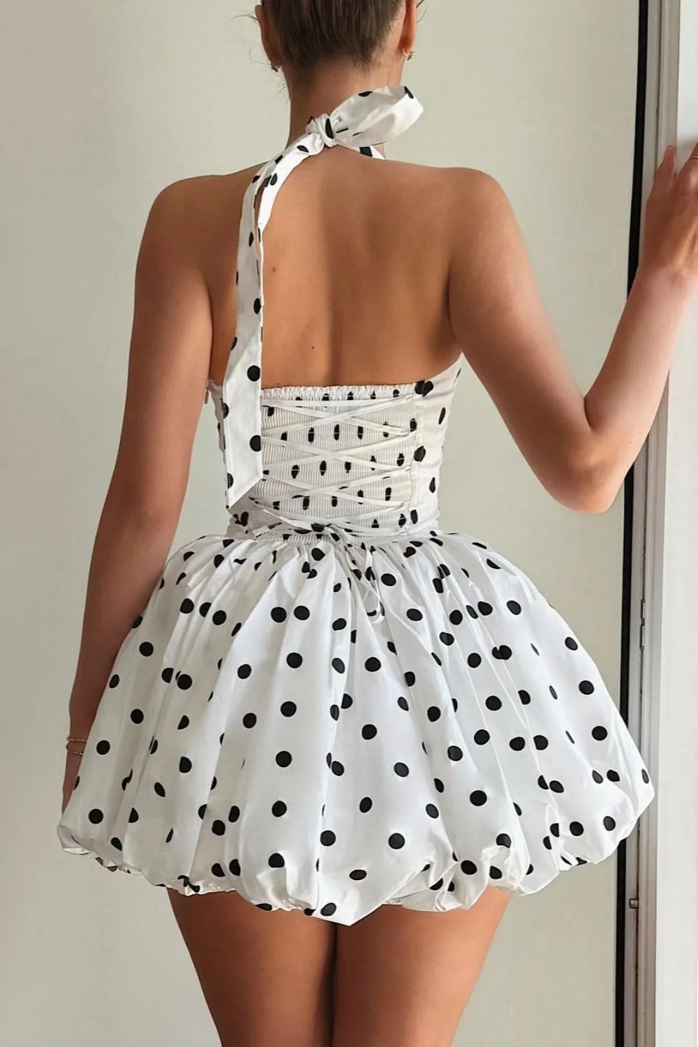 Sleeveless mini dress with halter neckline and polka dot print, fitted bodice and playful skirt — ideal for evening wear or warm days