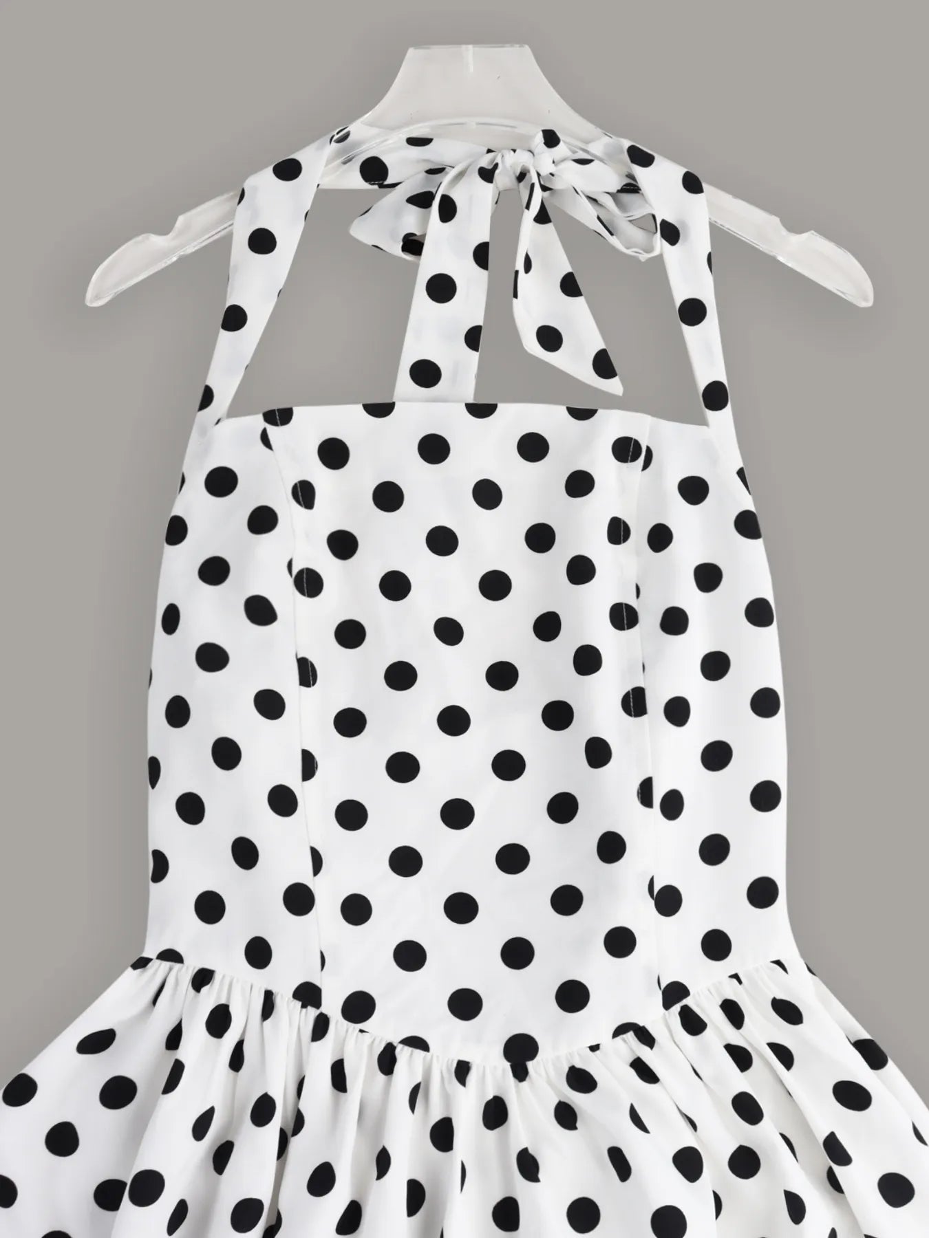 Sleeveless mini dress with halter neckline and polka dot print, fitted bodice and playful skirt — ideal for evening wear or warm days