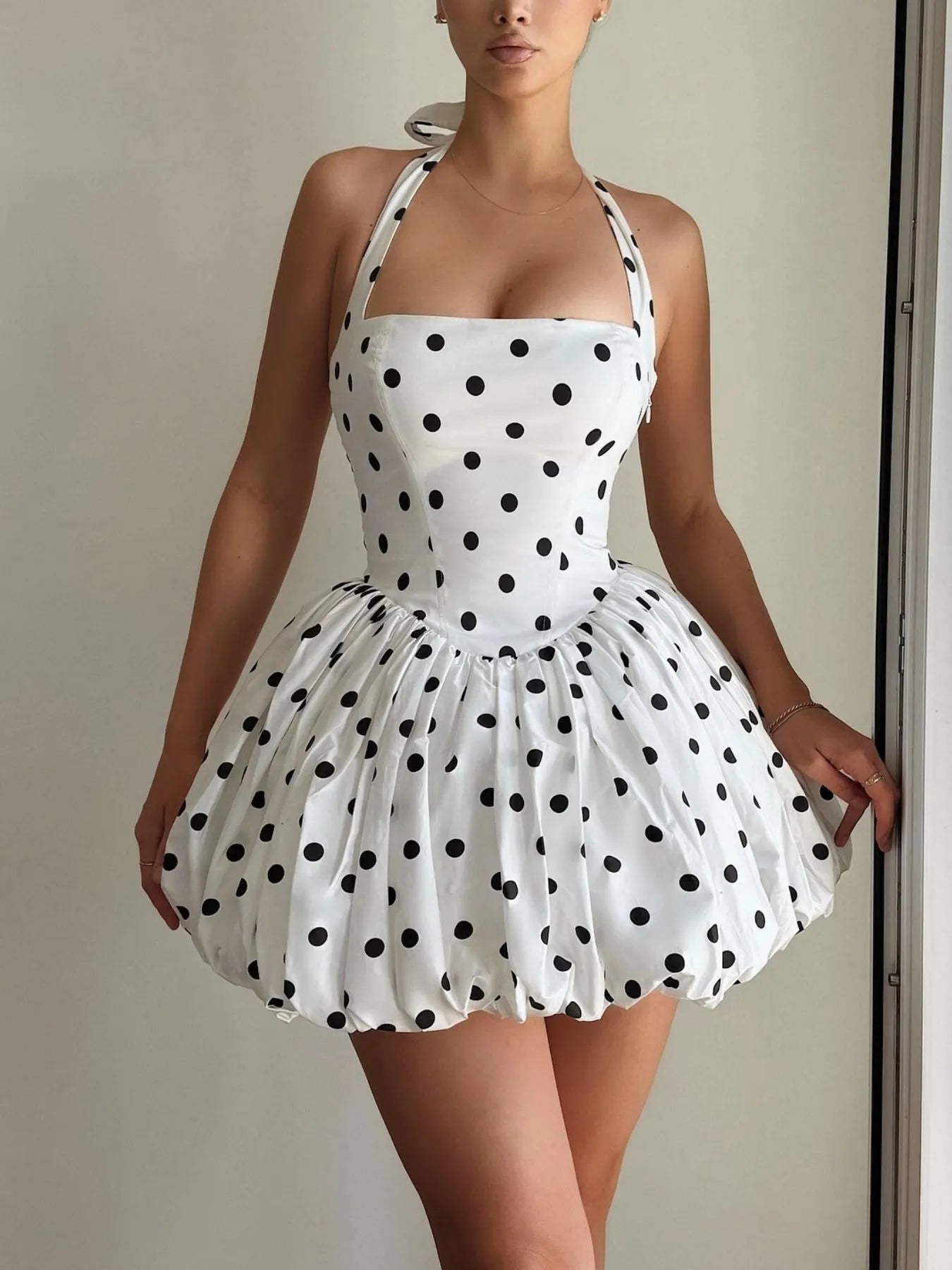 Sleeveless mini dress with halter neckline and polka dot print, fitted bodice and playful skirt — ideal for evening wear or warm days