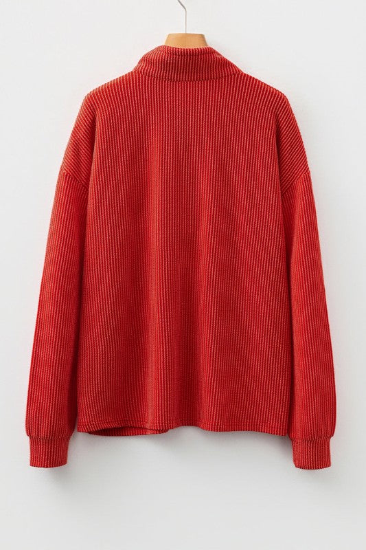 Red ribbed knit pullover with collar displayed on wooden hanger against white backdrop
