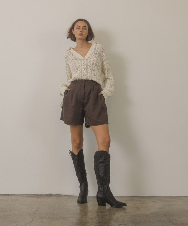 Knee-high western boots with embroidered stitching, pointed toe, stacked block heel, and side zipper closure.