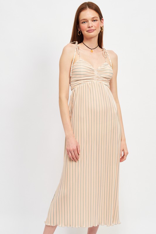 Woman wearing a beige pleated dress on a white background