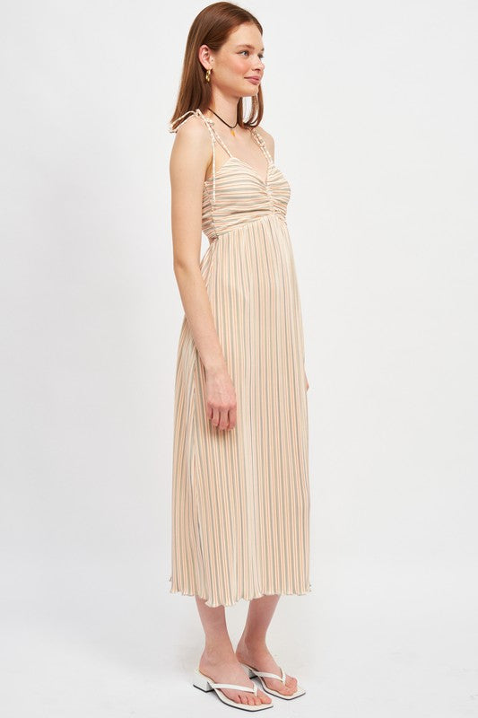 Woman wearing a beige pleated dress on a white background