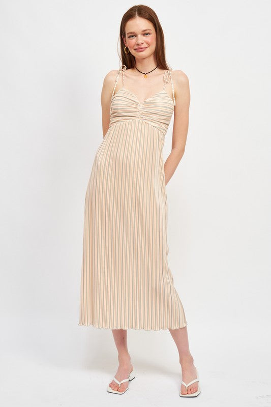 Woman wearing a beige pleated dress on a white background