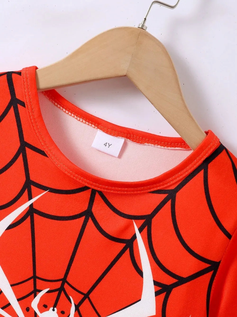 Children's shirt with spider web pattern on a hanger