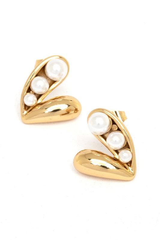 Gold earrings with a unique design. Each earring has a curved gold shape like a half-moon or a "C" facing downwards, with three pearls of different sizes set inside the curve. The background is plain white.