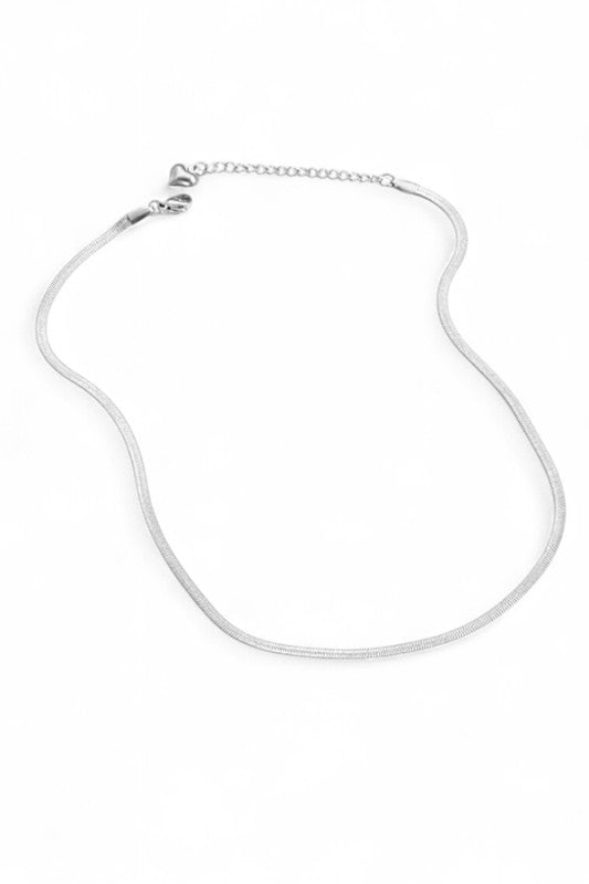 Lady wearing a sleek, minimalist silver necklace with a smooth, curved design, elegant, modern, and perfect for layering or solo statement styling.